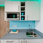 BOXFab Sleeping Unit: Well-equipped kitchen area complements double bed & full shower.